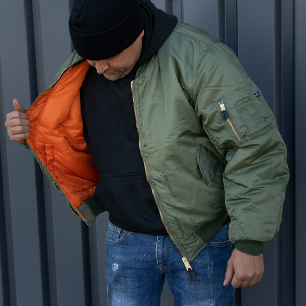 1214011 11 06 <strong>Materiaal:</strong> 100% hoogwaardig nylon ✔ <strong>Warme gewatteerde jas</strong> met binnenvoering ✔ <strong>Metalen ritssluiting</strong> voor extra duurzaamheid ✔ <strong>Twee steekzakken met drukknoop</strong> op de voorzijde ✔ <strong>Armzakje met metalen rits</strong> voor kleine accessoires ✔ <strong>Omkeerbare oranje binnenvoering</strong> voor extra zichtbaarheid ✔ <strong>Lage kraag</strong> voor een tijdloze look ✔ <strong>Verkrijgbaar in XXS t/m XXL</strong>, inclusief <strong>XS voor tieners vanaf 15 jaar</strong> <strong>Gewicht:</strong> 900 g <strong>Merk:</strong> Fostex Garments <strong>Perfect voor:</strong> <ul> <li>Beveiligingspersoneel & outdoor activiteiten</li> <li>Fans van militaire stijl & urban fashion</li> <li>Bescherming tegen kou en wind in alle seizoenen</li> <li>Streetwear en casual looks</li> </ul> Met zijn <strong>authentieke ontwerp</strong>, <strong>functionaliteit</strong> en <strong>tijdloze stijl</strong> is de <strong>MA-1 bomber jacket</strong> een must-have voor zowel militaire liefhebbers als modebewuste dragers! Voor de dames is het belangrijk om waarschijnlijk 1 maat kleiner te bestellen. <div><strong>Twijfel je over de maat, bestel dan één maatje groter. De jas valt wat kleiner uit.</strong></div> <div><a title="Maattabel" href="https://dedump.nl/wp-content/uploads/2025/01/Bomber-jas-dedump.nl_.pdf" target="_blank" rel="noopener noreferrer"><button><span style="color: #ef471f; font-size: medium;"><strong>Maattabel</strong></span></button></a></div>