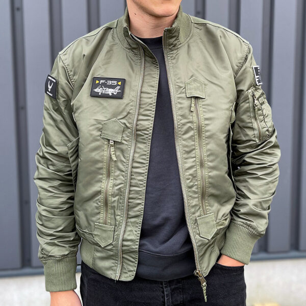 121425 11 f 35 flight jacket green De F-35 Flight Jacket is niet zomaar een bomberjack; het is een symbool van functionaliteit, stijl en duurzaamheid. Gemaakt van hoogwaardig 100% nylon, is dit tactical bomberjack ontworpen om je warm en comfortabel te houden in diverse omstandigheden. De polyester voering voegt extra warmte toe, waardoor dit jack ideaal is voor het tussenseizoen of als tussenlaag tijdens koude dagen. De jas sluit mooi aan op het lichaam dankzij de elastische boorden en mouwen, wat zorgt voor een comfortabele pasvorm en extra bescherming tegen de elementen. Maar dit jack biedt niet alleen comfort; het voegt ook stijl toe aan je look. Het tijdloze ontwerp van een bomberjack is zowel functioneel als trendy, en het past naadloos in het huidige straatbeeld. Het F-35 Flight Jacket is voorzien van handige details, zoals de sterke YKK hoofdrits, elastische boorden en mouwen, een elastische kraag en geventileerde oksels voor extra ademend vermogen. De jas heeft veel opbergruimte met twee steekzakken, twee ritszakken en zelfs een opbergvakje met rits en pennenvak op de linkermouw. Om het nog specialer te maken, wordt dit jack geleverd met 3 PVC patches met een Airforce thema, waardoor het een unieke uitstraling heeft. Kortom, het F-35 Flight Jacket is de perfecte combinatie van functionaliteit, stijl en duurzaamheid. Kies voor dit jack en wees klaar voor avontuur, zowel in de natuur als in de stad. <strong>Kenmerken:</strong> <ul> <li><big>Sterke YKK hoofdrits</big></li> <li><big>Inclusief 3 PVC patches (Airforce)</big></li> <li><big>Elastische boorden (onderzijde & mouwen)</big></li> <li><big>Elastische naad in de mouwen </big></li> <li><big>Elastische kraag </big></li> <li><big>Twee steekzakken met klittenband sluiting</big></li> <li><big>Twee ritszakken met veel opbergruimte</big></li> <li><big>Linkermouw voorzien van opbergvakje met rits en pennenvak</big></li> <li><big>Geventileerde oksels</big></li> </ul> <a title="Maattabel" href="https://dedump.nl/wp-content/uploads/2021/11/121425-F-35-Flight-Jacket.pdf" target="_blank" rel="noopener noreferrer"><button><span style="color: #ef471f; font-size: medium;"><strong>Maattabel</strong></span></button></a>
