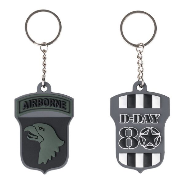 Sleutelhanger 3D PVC D Day 80 Airborne subdued 161 mDe Sleutelhanger 3D PVC D-Day 80 Airborne Subdued #161 is een unieke toevoeging aan je sleutelbos, met aan beide kanten iconische logo's: de Invasion Stripes/D-Day '44 en de Screaming Eagle.