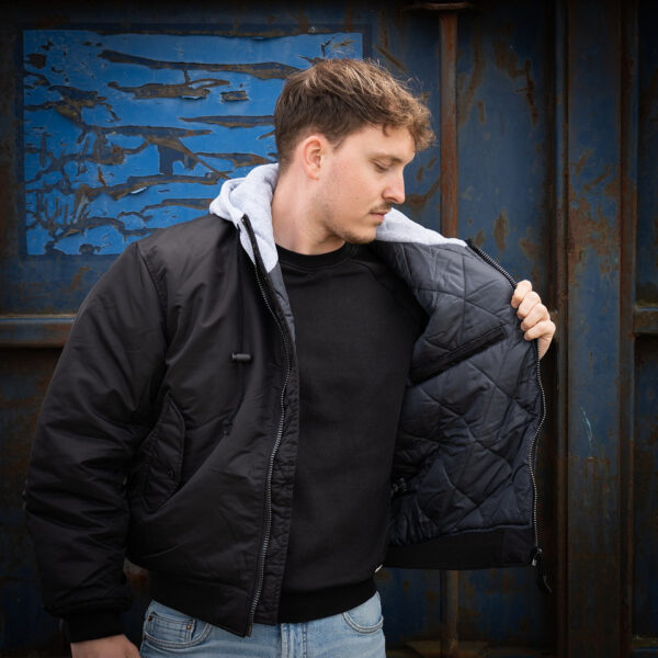 MA 1 hooded bomber jack10 Maak kennis met ons stijlvolle en authentieke MA-1 hooded bomber jack. Dit veelzijdige jack is ontworpen om zowel comfort als duurzaamheid te bieden, dankzij het gebruik van hoogwaardige materialen. De buitenstof is gemaakt van 100% nylon, de voeringstof van 100% polyester, en de stof van de hoodie is 100% katoen. Dit jack is perfect voor elk seizoen en elke gelegenheid, en combineert moeiteloos mode en functionaliteit.