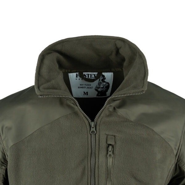 MA 1 Fleece Bomber Jacket6 De MA-1 Fleece Bomber Jacket combineert het beste van twee werelden: het comfort van een fleecejack en het iconische ontwerp van het MA-1 Bomberjack. Dit jack is gemaakt van superzachte fleece met nylon mouwen, waardoor het zowel warm als duurzaam is. Het jack is voorzien van een hoge kraag die extra bescherming biedt tegen de wind, perfect voor koude en winderige dagen. Het MA-1 Fleece Bomber Jacket is uitgerust met premium SBS ritsen voor soepele en betrouwbare sluiting. Twee zakken met ritssluiting aan de voorkant bieden voldoende opbergruimte voor je essentials, terwijl een borstzak met ritssluiting een handige plek biedt voor kleinere items. Het tijdloze ontwerp en de hoogwaardige materialen maken dit jack een uitstekende keuze voor dagelijks gebruik.