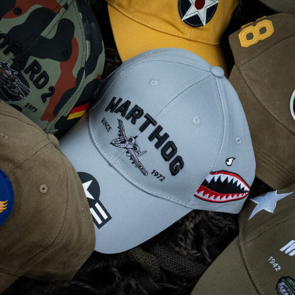 Baseball Cap A 10 Thunderbolt warthog5 De <strong>Baseball Cap A-10 Thunderbolt "Warthog"</strong> is een eerbetoon aan het legendarische gevechtsvliegtuig van de United States Air Force (USAF). De A-10 Thunderbolt, ook wel bekend als de "Warthog", is het enige vliegtuig dat speciaal is ontworpen voor luchtsteun op het slagveld. Dit robuuste toestel staat bekend om zijn indrukwekkende bewapening en vermogen om op lage hoogte te vliegen, ondanks zijn "ruwe" uiterlijk en lagere snelheid. Op de voorkant van de cap prijkt trots het woord 'Warthog', een bijnaam die het vliegtuig kreeg vanwege zijn unieke en functionele ontwerp.