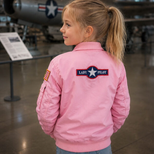 121432 23 09 De Kinder MA-1 Flight Jacket in het roze is de perfecte combinatie van stoer en schattig voor jonge avonturiers. Geïnspireerd op de klassieke bomberjas, heeft deze jacket vrolijke geborduurde emblemen zoals 'Women Airforce', 'Top Gun' en de Amerikaanse vlag. Met praktische details zoals vliegtuigvormige ritsen en een mouwvakje met pennenvakje, is deze jas niet alleen trendy maar ook functioneel. Gemaakt van 100% nylon aan de buitenkant en 100% polyester aan de binnenkant, biedt deze jas comfort en stijl.