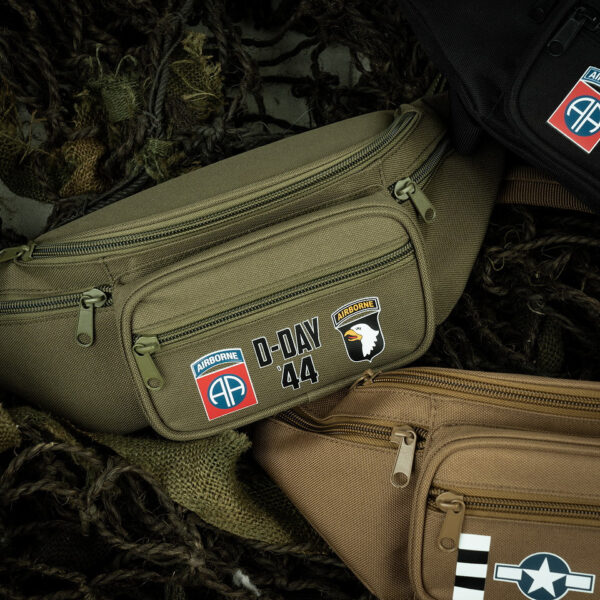359395 11 04 1 De Heuptas D-Day 1944 Airborne is een functionele en stijlvolle tas, perfect voor festivals of tijdens het reizen. Gemaakt van 100% polyester, biedt deze heuptas met verstelbare band en gespsluiting vijf handige vakken met ritssluiting voor het veilig opbergen van waardevolle spullen zoals geld en passen. Een must-have accessoire voor de avontuurlijke reiziger.